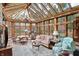 Bright sunroom with walls of windows, skylights, comfortable seating, and an elegant chandelier at 10614 Winterwood, Carmel, IN 46032