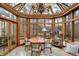 Charming sunroom features natural light from the skylights and windows with a chandelier and dining area at 10614 Winterwood, Carmel, IN 46032