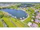Aerial view of lakeside homes with private docks and boats, surrounded by lush greenery and a scenic lake at 10792 Harbor Bay Dr, Fishers, IN 46040