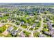 Scenic aerial view of a neighborhood with manicured lawns, mature trees, and well-maintained streets on a sunny day at 10792 Harbor Bay Dr, Fishers, IN 46040