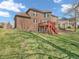 Brick house's backyard with lush lawn, a red deck and staircase, perfect for outdoor enjoyment at 10792 Harbor Bay Dr, Fishers, IN 46040