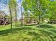 Verdant backyard offering scenic views of the home with a red deck and abundant green space at 10792 Harbor Bay Dr, Fishers, IN 46040