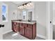 Bathroom with dual sinks, wooden cabinets, neutral walls, and modern vanity lighting at 10792 Harbor Bay Dr, Fishers, IN 46040