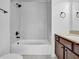 Cozy bathroom features a shower over tub, tiled walls, and updated fixtures in neutral tones at 10792 Harbor Bay Dr, Fishers, IN 46040