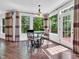 Bright breakfast nook with hardwood floors, neutral curtains, and a green view of the trees outside at 10792 Harbor Bay Dr, Fishers, IN 46040