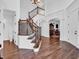 Grand foyer featuring a staircase with wood and iron railings, hardwood floors, and an open view to the dining area at 10792 Harbor Bay Dr, Fishers, IN 46040