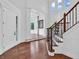 Inviting foyer showcasing hardwood floors, staircase, and an arched entryway to a bright, window-filled room at 10792 Harbor Bay Dr, Fishers, IN 46040