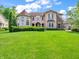 This two-story residence features a turret, balcony, and a blend of brick and stone accents on a green lawn at 10792 Harbor Bay Dr, Fishers, IN 46040