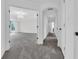 Bright hallway with gray carpet leading to a spacious room with tray ceilings and a chandelier at 10792 Harbor Bay Dr, Fishers, IN 46040