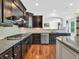 Modern kitchen featuring dark cabinets, granite countertops, and stainless steel appliances at 10792 Harbor Bay Dr, Fishers, IN 46040