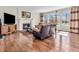 Inviting living room featuring a fireplace, hardwood floors, comfortable seating, and natural light from large windows at 10792 Harbor Bay Dr, Fishers, IN 46040