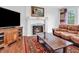 Comfortable living room featuring a fireplace, hardwood floors, comfortable seating, and a television at 10792 Harbor Bay Dr, Fishers, IN 46040