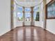 Bright room with tray ceilings, hardwood floors, large windows offering natural light, and stylish curtains at 10792 Harbor Bay Dr, Fishers, IN 46040
