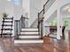 An elegant foyer showcasing hardwood floors and a staircase with wooden steps and iron balusters at 10792 Harbor Bay Dr, Fishers, IN 46040