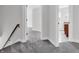 Carpeted stairs leading to a hallway with a wood handrail at 10792 Harbor Bay Dr, Fishers, IN 46040