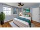 Bright bedroom features a queen bed with modern decor, a ceiling fan, and a view through large windows at 110 E Washington St # 802, Indianapolis, IN 46204