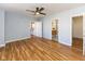 Bright bedroom featuring hardwood floors, a ceiling fan, and a bathroom with modern fixtures at 110 E Washington St # 802, Indianapolis, IN 46204