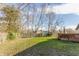 View of a grass backyard with a wooden fence and deck at 11930 Titania Cir, Indianapolis, IN 46236