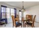 Sunlit dining room with wood table, upholstered chairs, and sheer blue curtains at 11930 Titania Cir, Indianapolis, IN 46236