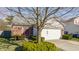 Well-maintained home featuring a brick exterior, white garage door, and mature trees in the front yard at 11930 Titania Cir, Indianapolis, IN 46236