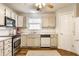 Well-lit kitchen featuring white cabinets, stainless steel appliances, and hardwood floors with an accent rug at 11930 Titania Cir, Indianapolis, IN 46236