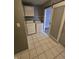 Convenient laundry room with tile flooring, washer, dryer, and overhead cabinet at 1410 St Paul St, Indianapolis, IN 46203