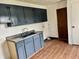 Practical laundry area features painted cabinets, a utility sink, and durable laminate flooring at 151 N 8Th Ave, Beech Grove, IN 46107