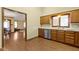 Partially-viewed kitchen with stainless steel appliances and wood cabinets connects to the living area at 153 Monticello Ct, Noblesville, IN 46060