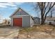 View of the detached single car garage with red door and concrete driveway at 1540 N Chester Ave, Indianapolis, IN 46201