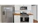 Stainless steel appliances with butcher block countertops and white cabinetry in the updated kitchen at 1540 N Chester Ave, Indianapolis, IN 46201