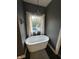 This bathroom features a modern tub with a view of the pool and lush backyard through the window at 1740 Golden Field Dr, Greenwood, IN 46143