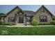 Charming brick home featuring a well-manicured lawn, professionally landscaped shrubbery, and a covered front porch at 1740 Golden Field Dr, Greenwood, IN 46143