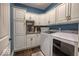 Well-lit laundry room with white cabinets, modern appliances, and blue accent wall at 1740 Golden Field Dr, Greenwood, IN 46143