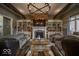 Elegant living room showcasing a stone fireplace, wooden beam accents, built-in shelving, and neutral-toned furniture at 1740 Golden Field Dr, Greenwood, IN 46143