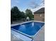 In-ground swimming pool with an automatic safety cover and patio furniture in a landscaped backyard at 1740 Golden Field Dr, Greenwood, IN 46143