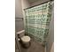 This bathroom features a white toilet, shower with a cactus patterned curtain, and gray plank flooring at 1740 Golden Field Dr, Greenwood, IN 46143