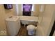 Bathroom with a white sink, toilet, and clawfoot bathtub under a window with purple curtain at 18 N Sherman Dr, Indianapolis, IN 46201