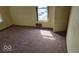 Bedroom featuring tan walls, brown carpet and a window, with a vent under the window at 18 N Sherman Dr, Indianapolis, IN 46201