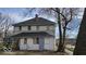 Back of a two-story home with boarded windows and deferred maintenance at 18 N Sherman Dr, Indianapolis, IN 46201