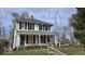 Two-story home with a covered porch, boarded windows, and some deferred maintenance at 18 N Sherman Dr, Indianapolis, IN 46201