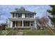 Two-story home with a covered porch, boarded windows, and some deferred maintenance at 18 N Sherman Dr, Indianapolis, IN 46201