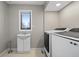 Functional laundry room with modern washer, dryer, and utility sink near a window at 19041 Karyn Ln, Westfield, IN 46062