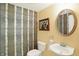 Stylish powder room with decorative wallpaper, an oval mirror, and a pedestal sink at 226 N Cleveland St # 226E, Indianapolis, IN 46204