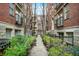 Attractive courtyard view of brick apartment buildings with a landscaped walkway and wrought iron gated entrance at 226 N Cleveland St # 226E, Indianapolis, IN 46204