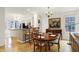 Bright dining area featuring an adjacent kitchen, hardwood floors, modern lighting, and stylish decor at 226 N Cleveland St # 226E, Indianapolis, IN 46204