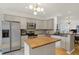 Open kitchen features stainless steel appliances, an island with a butcher block countertop, and gray cabinets at 226 N Cleveland St # 226E, Indianapolis, IN 46204