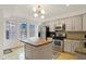 Bright kitchen with stainless steel appliances, wood floors, light grey cabinets and modern lighting fixture at 226 N Cleveland St # 226E, Indianapolis, IN 46204
