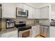 Kitchen features stainless steel appliances, granite countertops, a tile backsplash, and gray cabinets at 226 N Cleveland St # 226E, Indianapolis, IN 46204