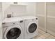 Laundry room with white washer and dryer, white walls, and white shelving unit at 226 N Cleveland St # 226E, Indianapolis, IN 46204