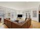 Sun-filled living room with a large sectional sofa, hardwood floors, and multiple windows with courtyard views at 226 N Cleveland St # 226E, Indianapolis, IN 46204